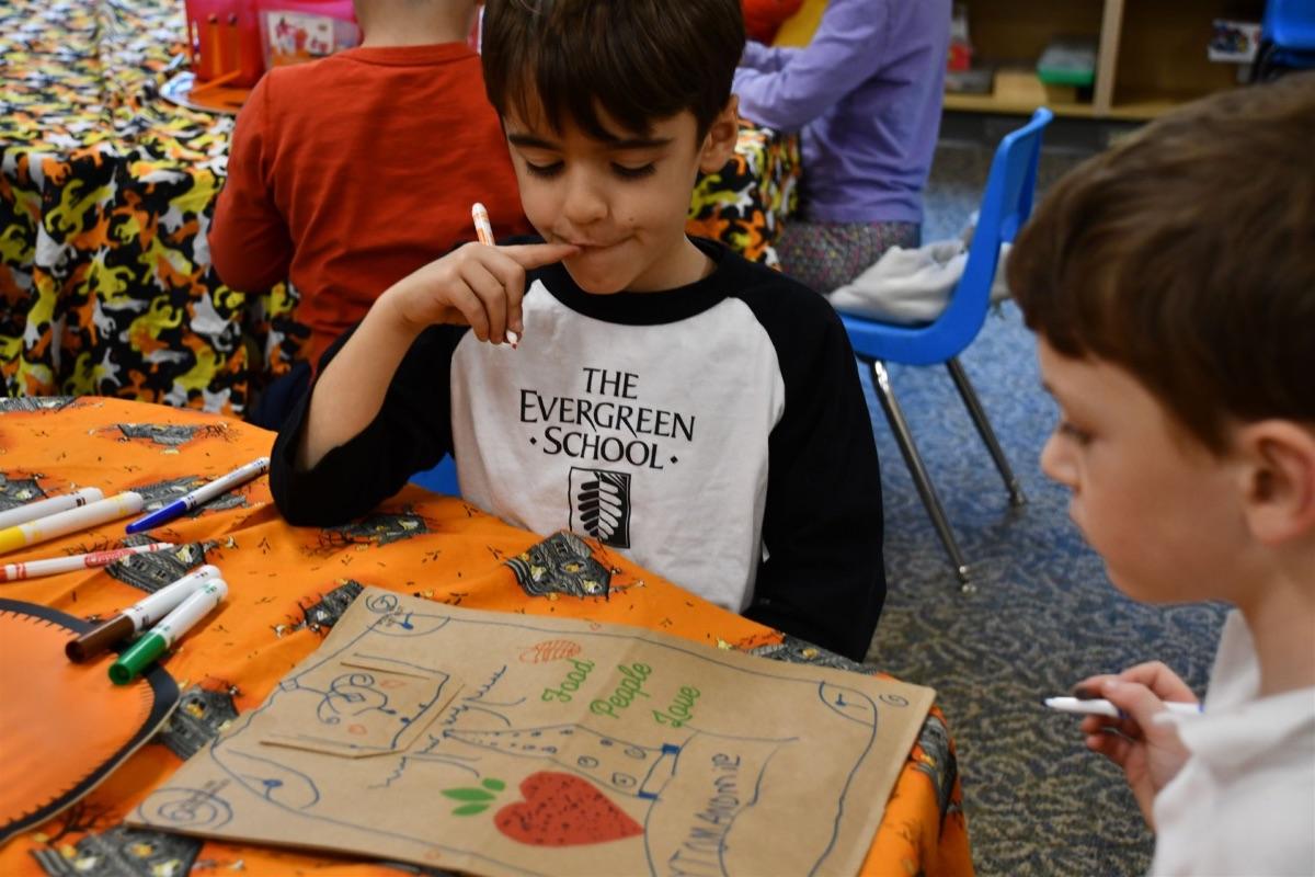 1st graders decorating bags for a food drive