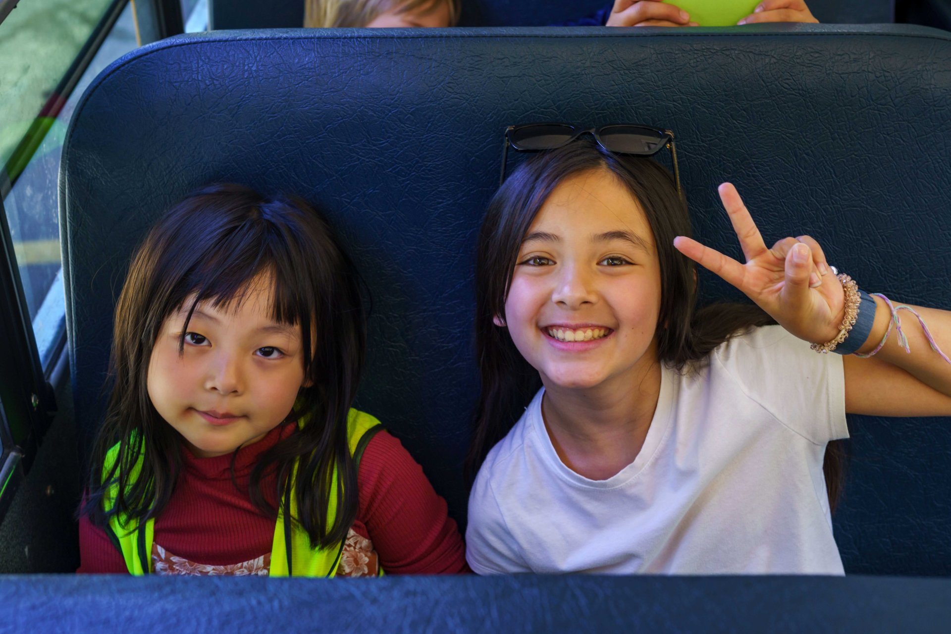 a preschool student sitting and smiling with an older buddy student