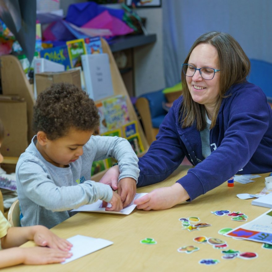 focused young student working with a teacher at a table