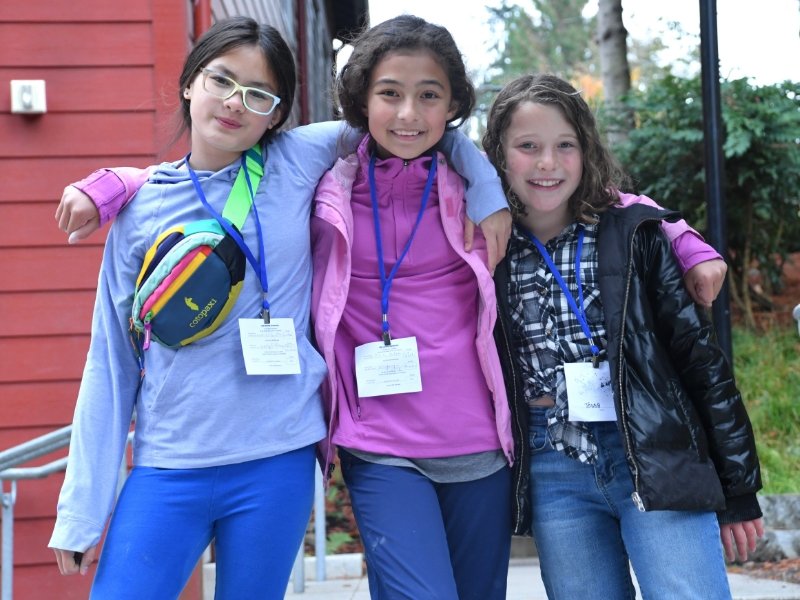 3 students standing together smiling