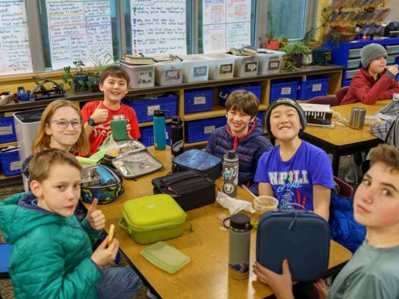group of students eating lunch together in the classroom