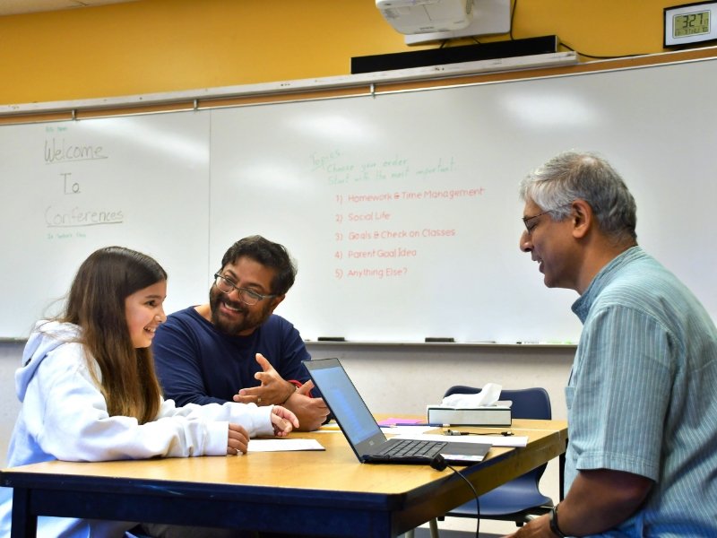 student and parent with teacher during student-led conferences