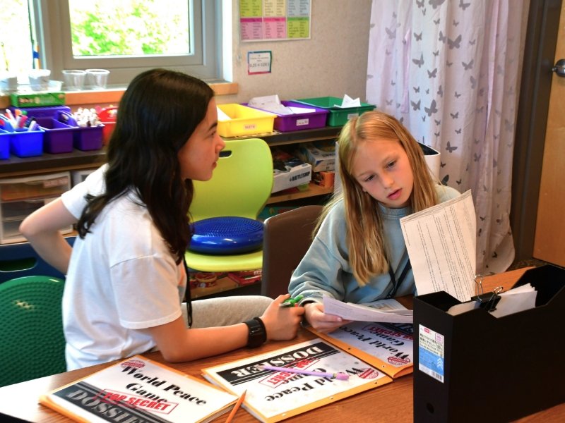 two 4th grade students talking together as they work on the "world peace game"