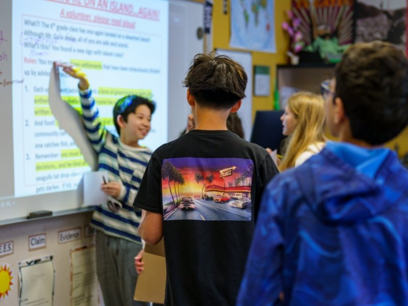 student presenting at a whiteboard to classmates