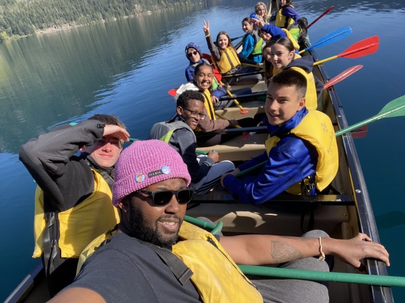 students and teacher paddling a boat in the middle of a sunny lake on the Olympic Peninsula
