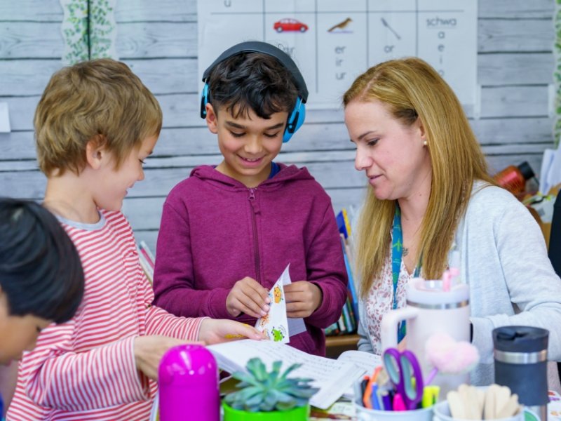 teacher working 2 students