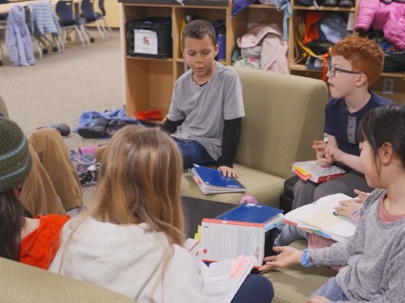 group of students talking to each other in common area between classrooms