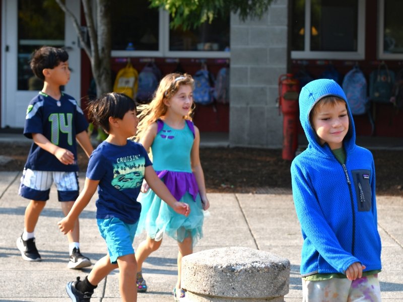 group of students walking outside in front of the school building