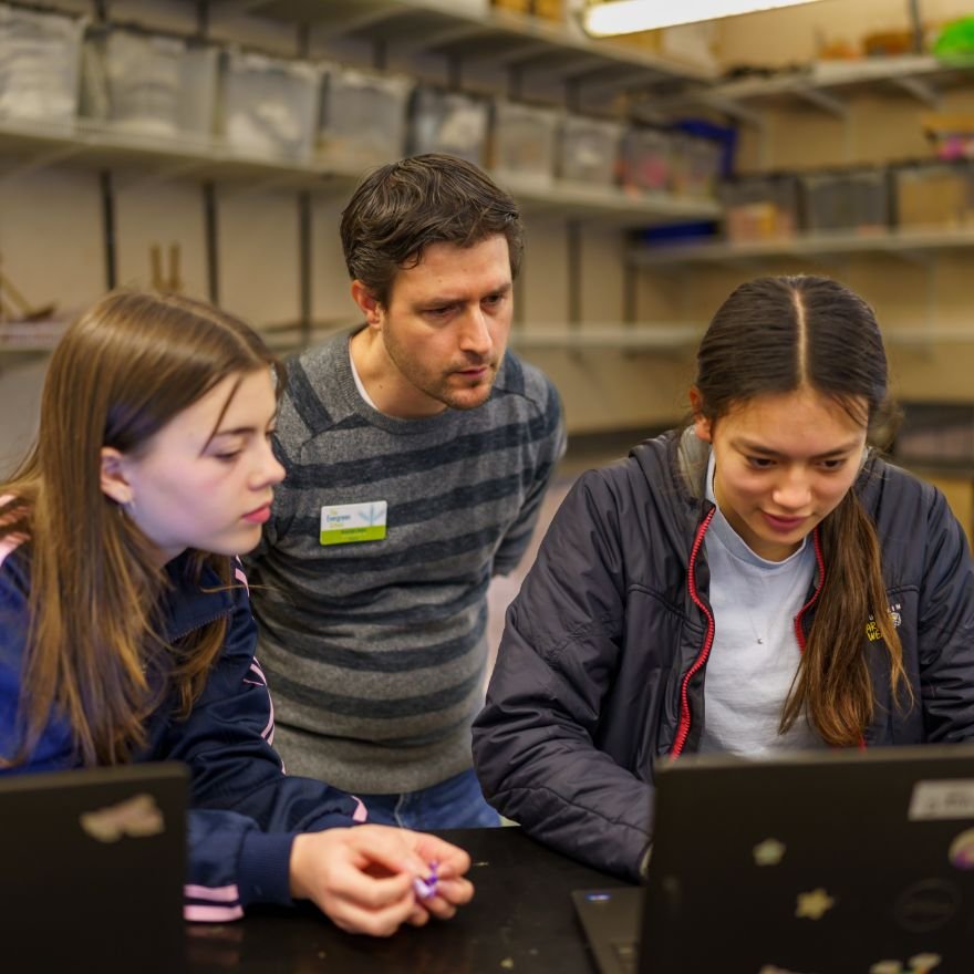 middle school students working on a science project with their teacher